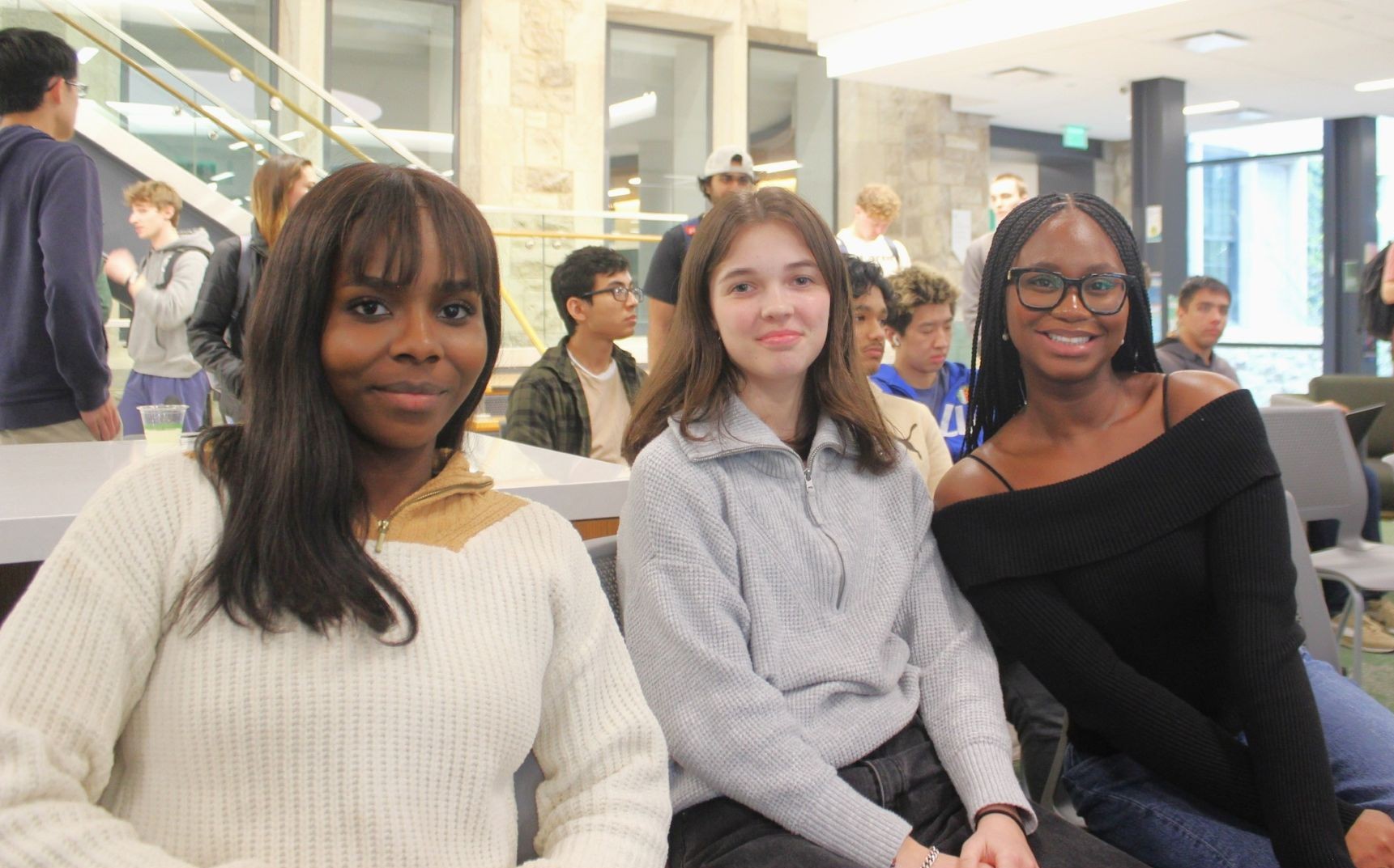 Three students sit and pose together during Loyola's Hack-a-thon.