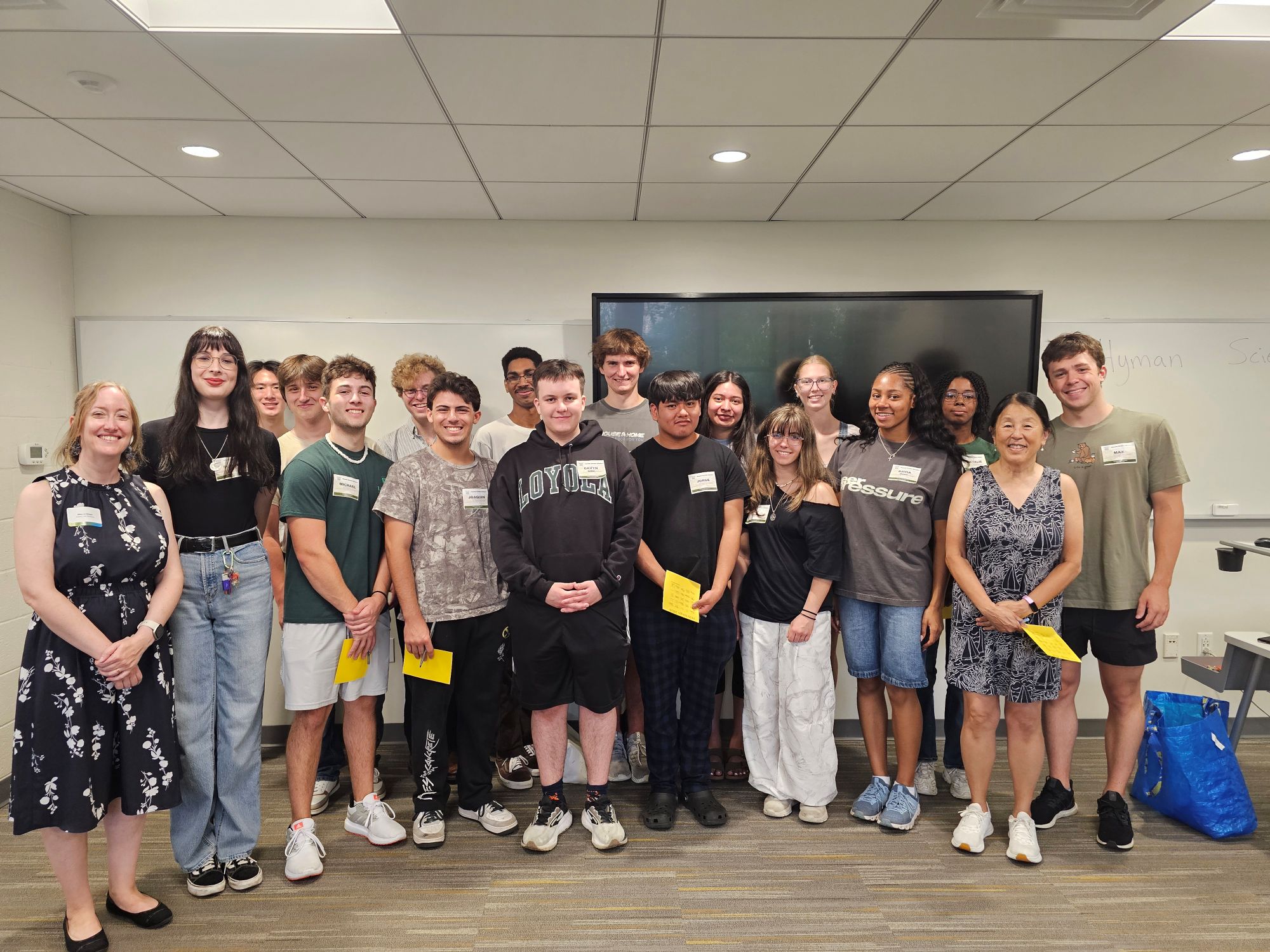 A group of students in the Hyman Science Scholars pose together in a classroom.