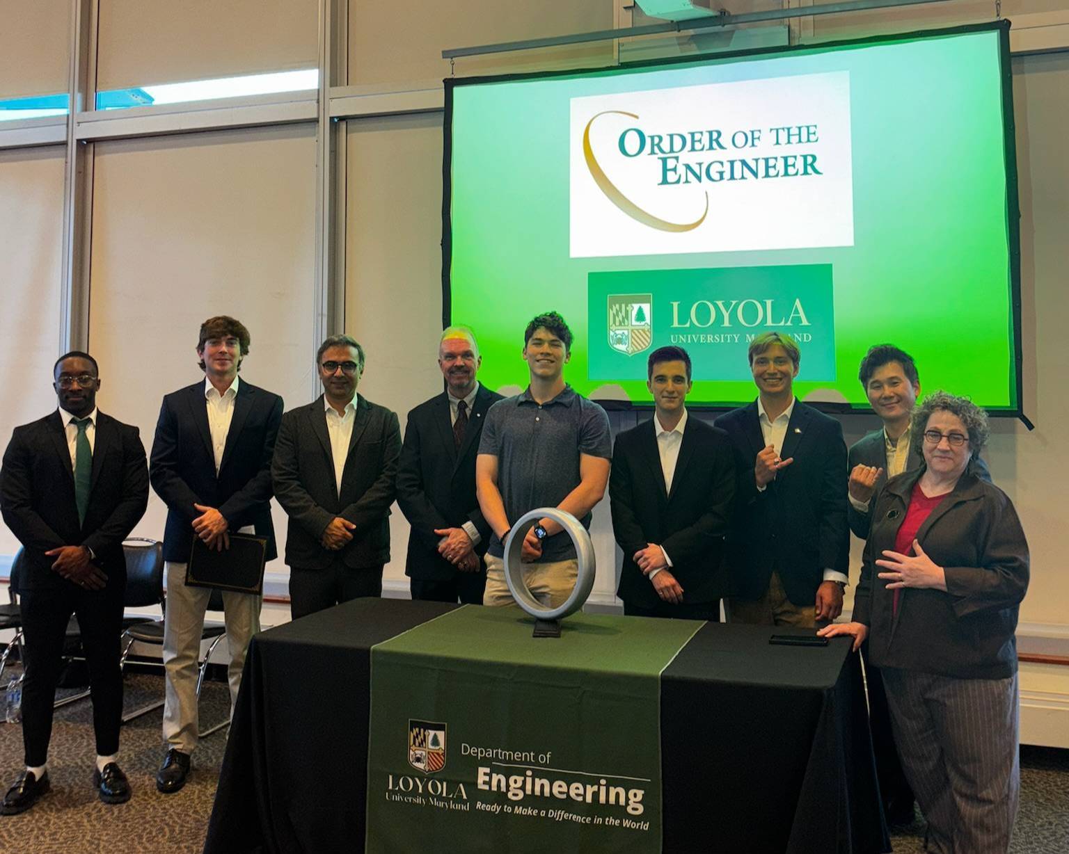 Students and faculty inducted to the Order of the Engineer pose at a table.