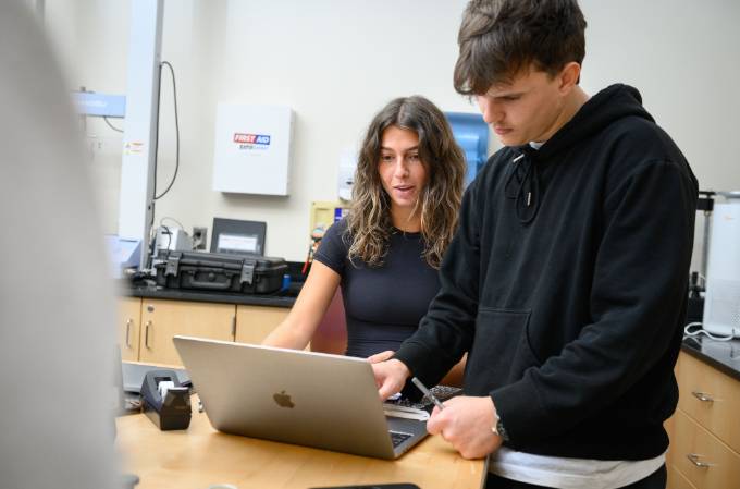 Two computer engineering students working on a laptop
