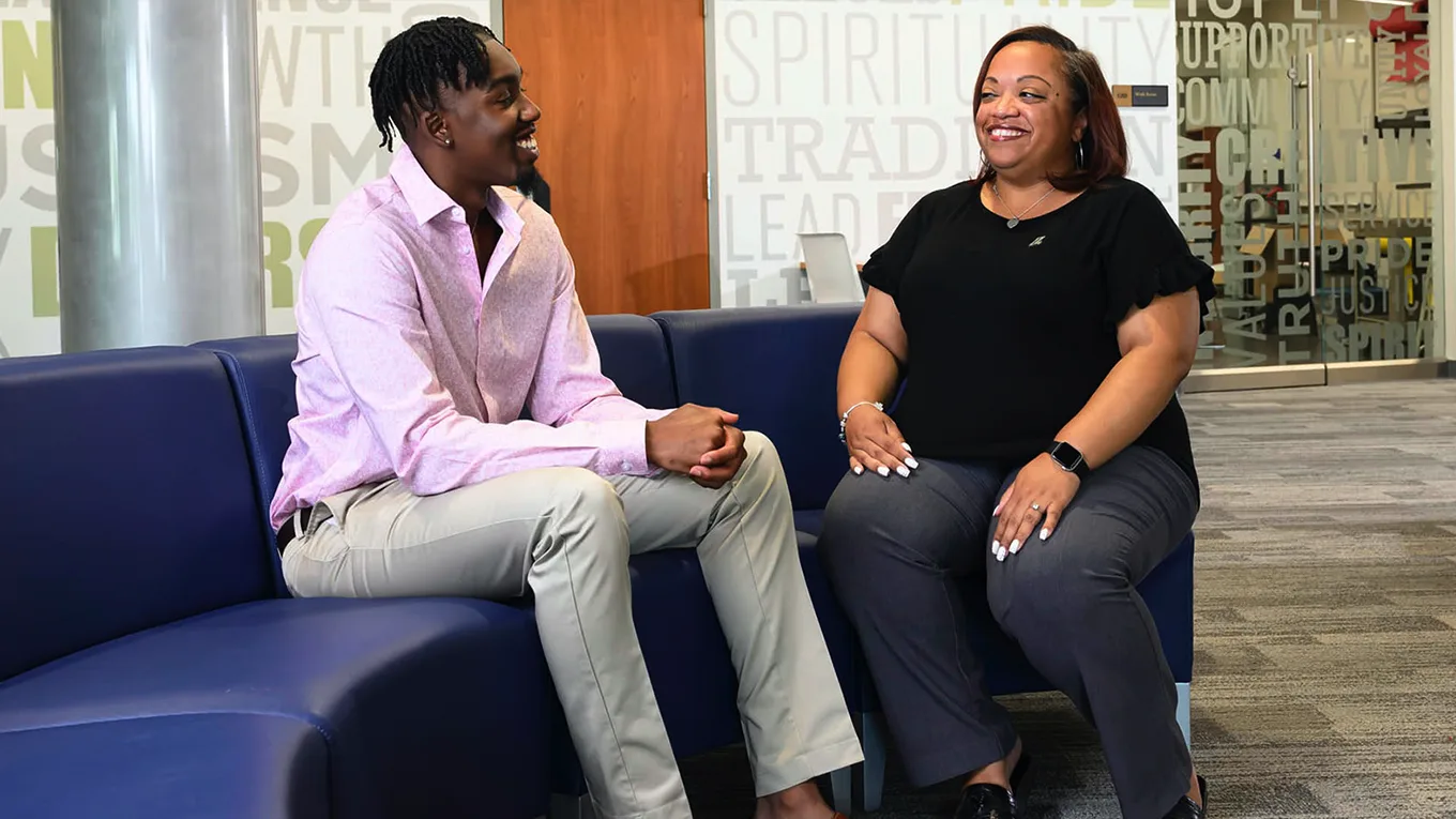 A student and an advisor talk while sitting on a blue couch - Press enter to play