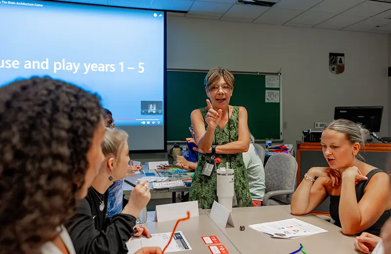 A professor in front of a class of graduate students