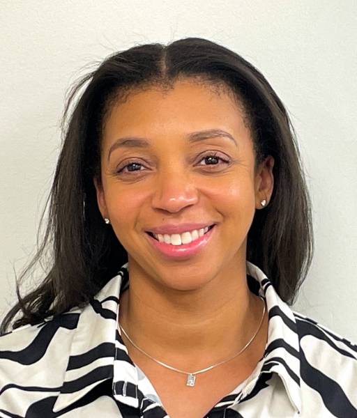 Headshot of Whitley Abrams in white collared shirt with black pattern