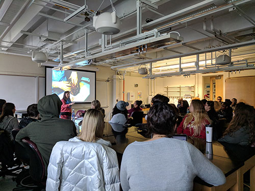 Dr. Krystal Hans speaking to a large class