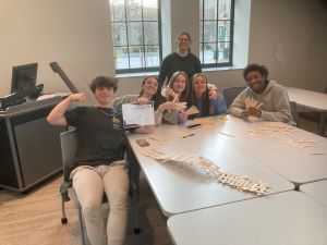 students and faculty posing with their small wooden bridges