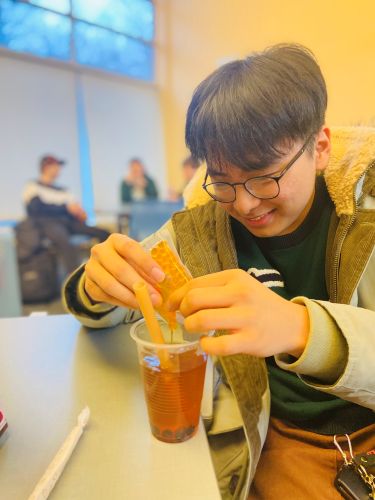 college student adding boba to their bubble tea