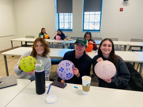 college students posing with painted lanterns