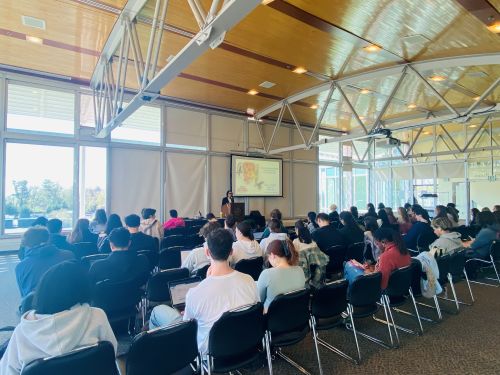 speaker in front of a large room of college students