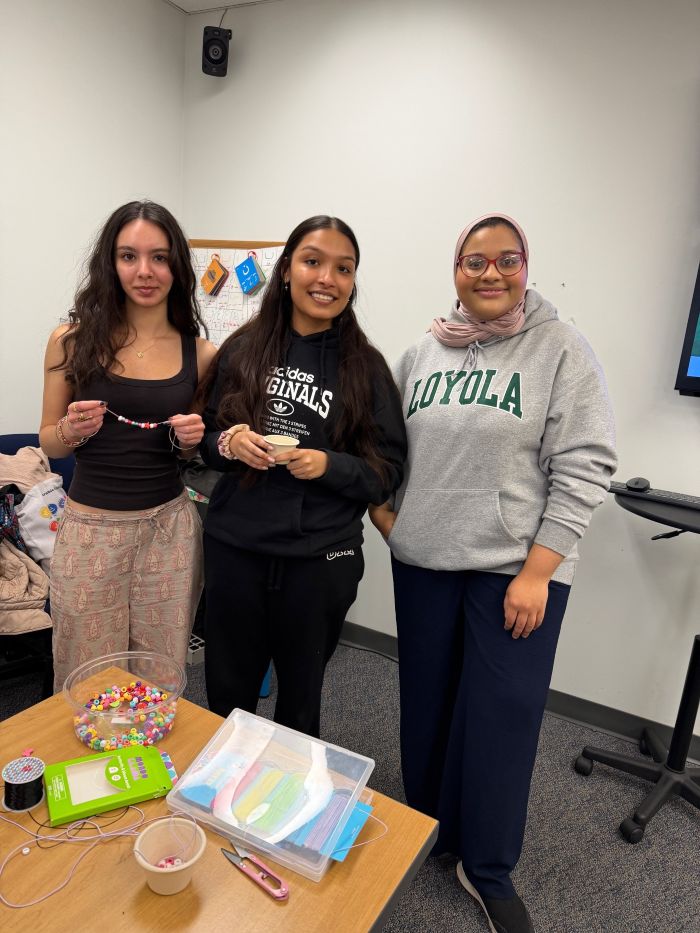 students posing with handmade bracelets