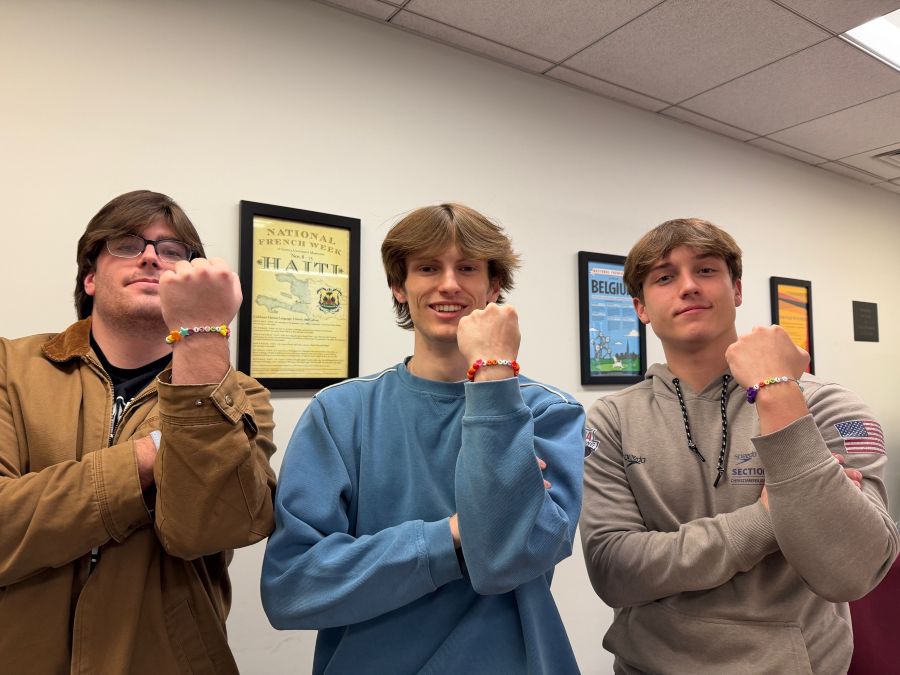 students posing with handmade bracelets