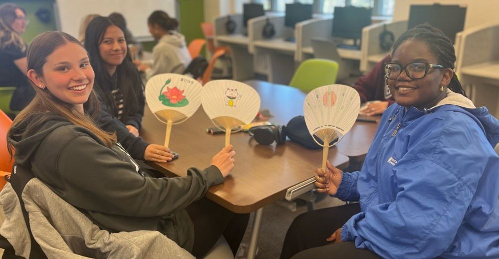 students posed with paper crafts