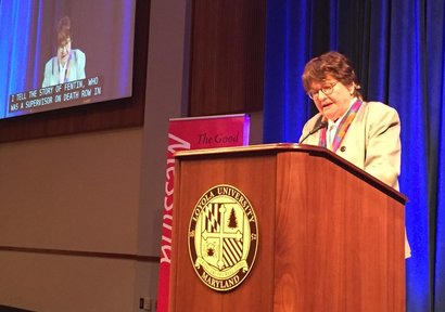 Prejean standing at lectern