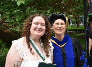 Ally Moore and Dr. Konradi smiling in front of a verdant background.