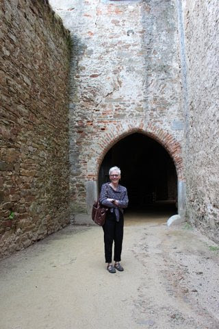 Dr. Barbara Vann posing in front of a castle in the Czech Republic.