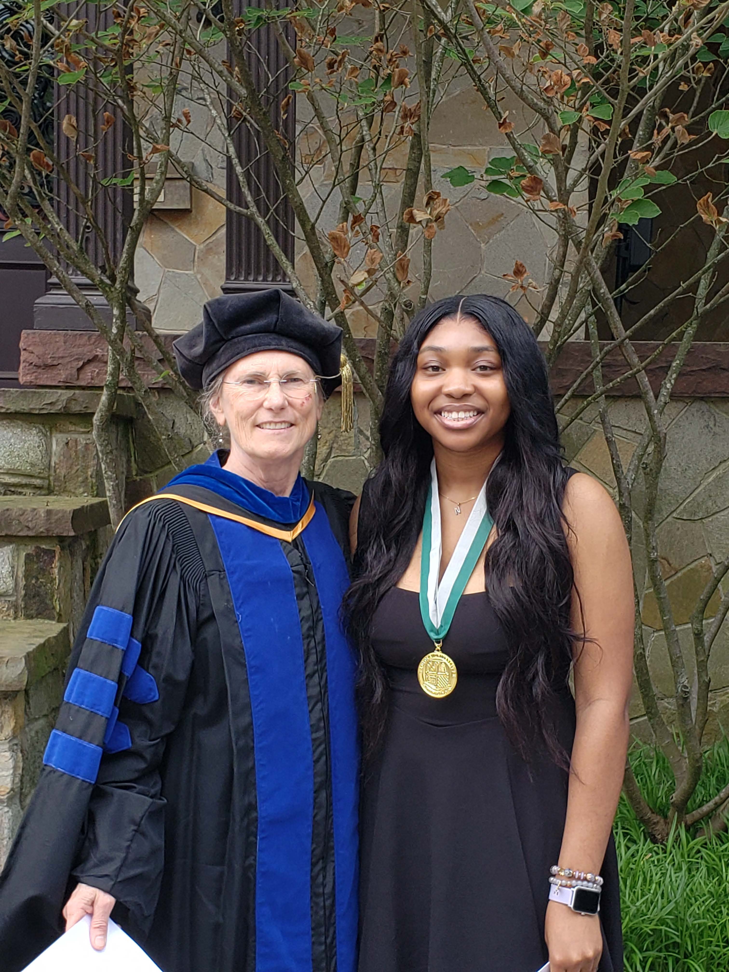 Nosa smiling with her medal, standing next to Dr. Konradi