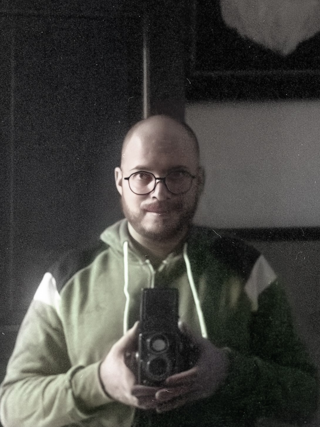 Self-portrait of Cyrus Feldman taking a picture of his reflection in a mirror