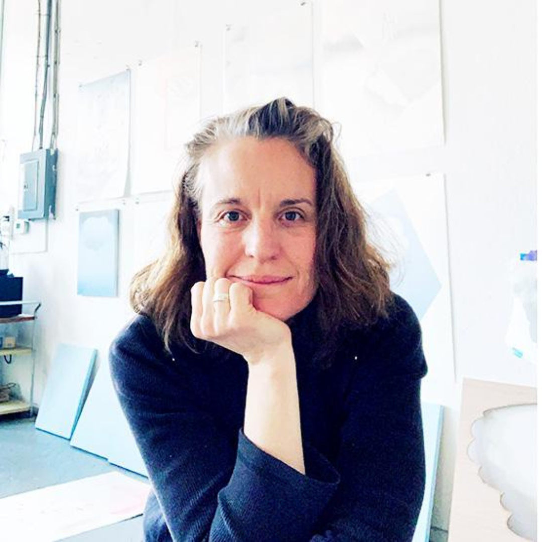 Janet Olney resting her head in her hand and smiling