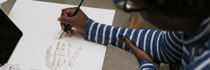 Person drawing a detailed sketch of a hand on white paper.
