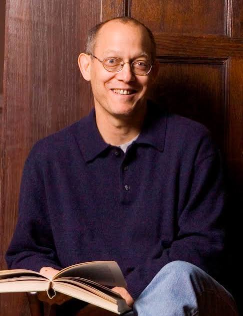 Alan Shapiro posing in front of brown backdrop