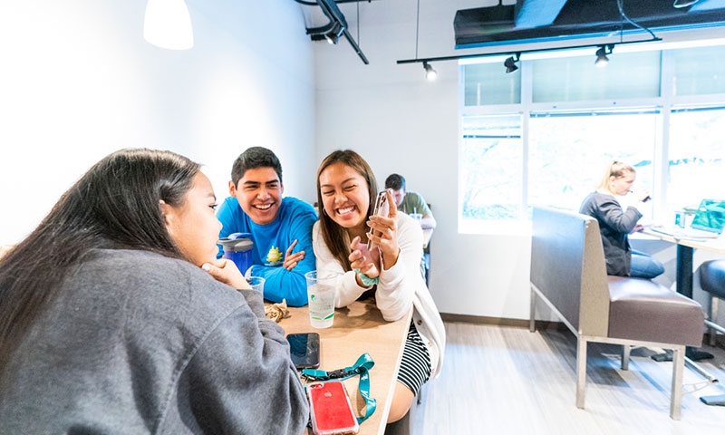 students gather at a table to discuss the latest going on