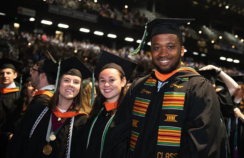 Students during commencement smiling for the camera