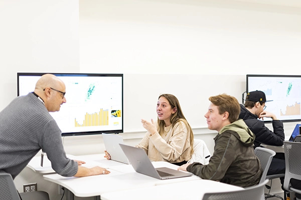 Professor engages in discussion with two students