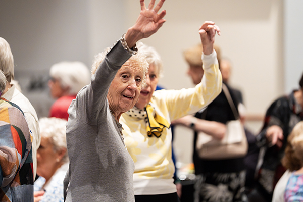 A pair of Mount Saint Agnes Alumnae wave a fond hello to an old friend from across the room