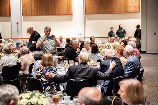 A group of Golden Greyhounds poses for a photo around a table at the 2025 Alumni Jubilee Luncheon