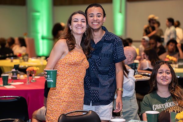 Two seniors pose with proud smiles at Loyola