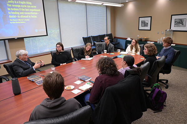 A guest lecturer addresses Loyola students in a conference room on the Evergreen campus