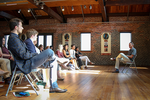 A Loyola graduate addresses a group of Loyola students during a site visit at the Frederick Douglass-Isaac Myers Maritime Park Museum