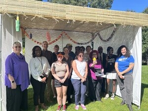 Loyola students, staff, and faculty celebrating Sukkot under a Sukkah on the Quad