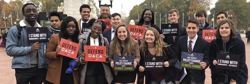 Students holding signs of support for various policy change issues