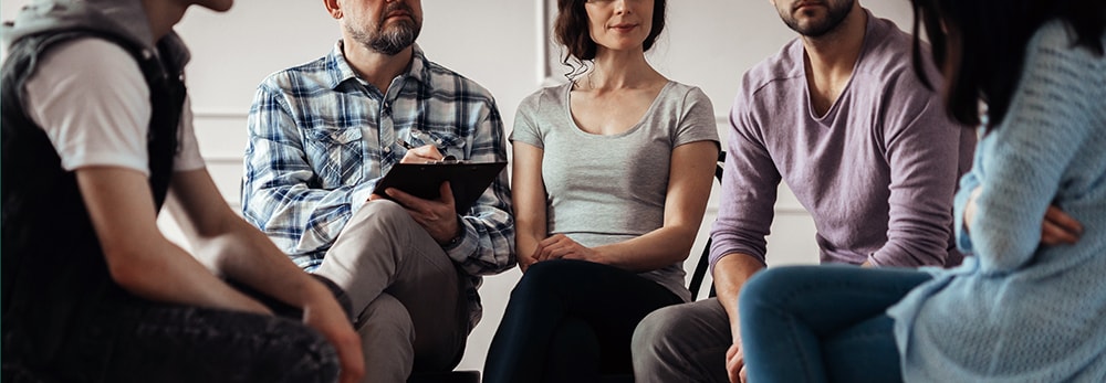 Clients seated in a circle during a group psychotherapy session