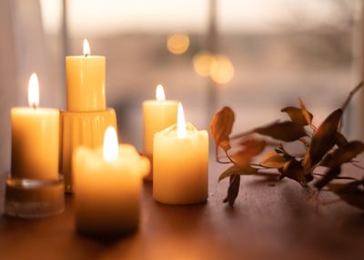 photo of candles on a wood surface, next to a dried branch