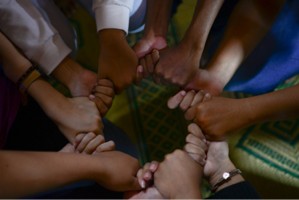 Group of people holding each other thumbs in a circle