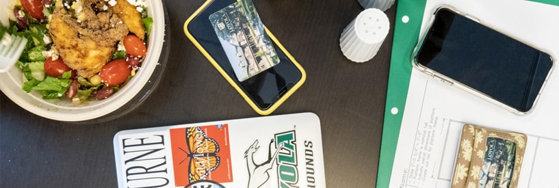 Phones, laptops, schoolwork, and some food on a table in the Student Center