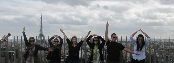 Students making a LOYOLA sign with their bodies with the Eiffle tower of Paris in the background