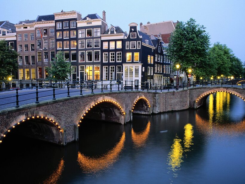 Bridge lit up at dusk over a canal