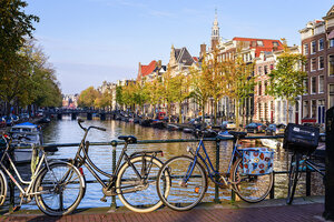Bikes locked up with the Amsterdam canals in the background