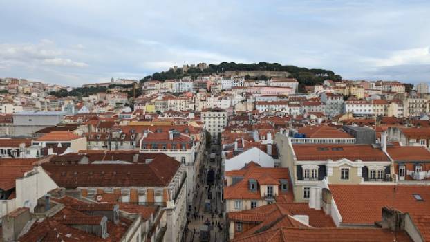A photo of a city scape, roofs that are red and buildings on a hill