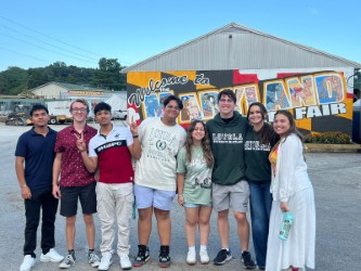 A group of people standing in front of a sign that says Maryland State fair
