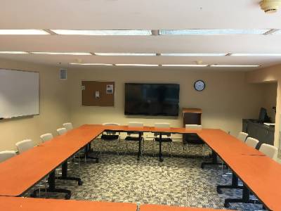 tables arranged in rectangle, large television, whiteboard