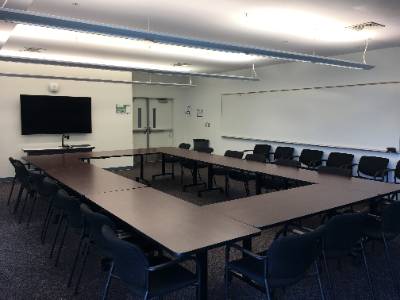 tables arranged in rectangle, large television