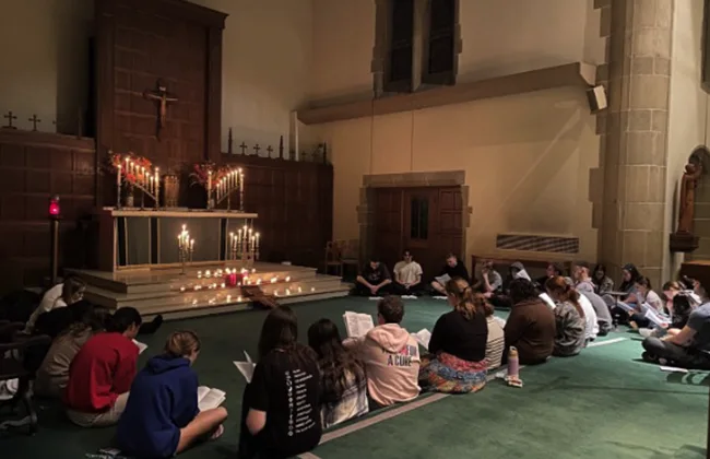 People gathering for a discussion on the Alumni Memorial Chapel floor