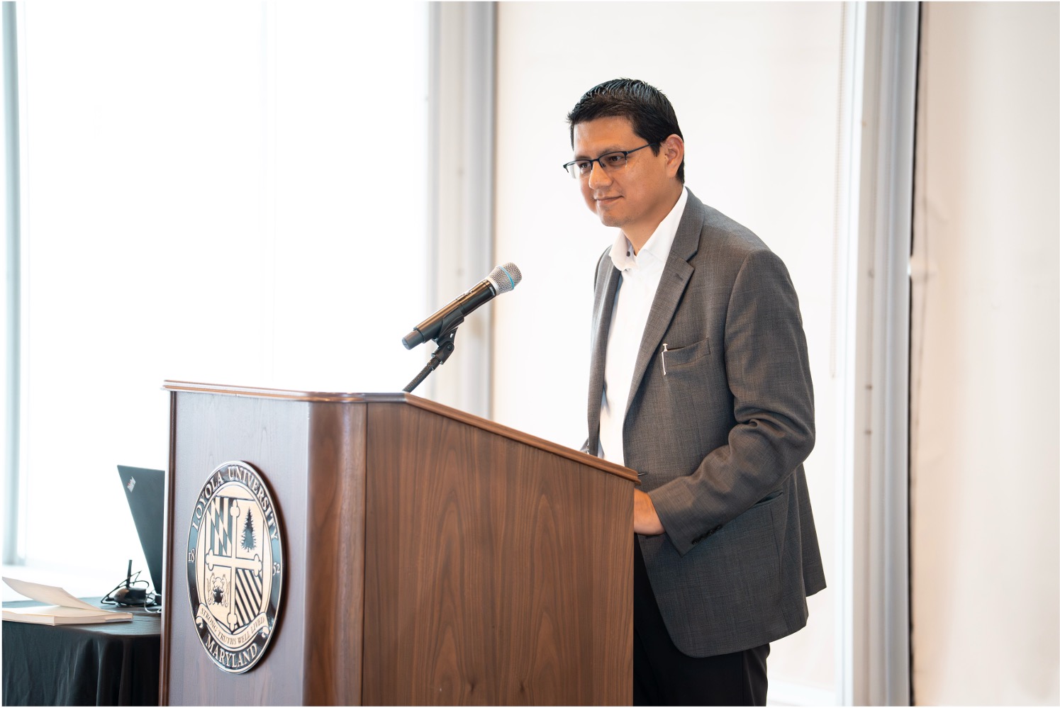 Milton Bravo speaking in front of a podium
