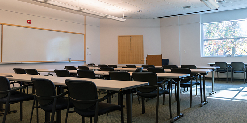 Tables and chair in a classroom with a window and whiteboard at the Fitness and Aquatic Center