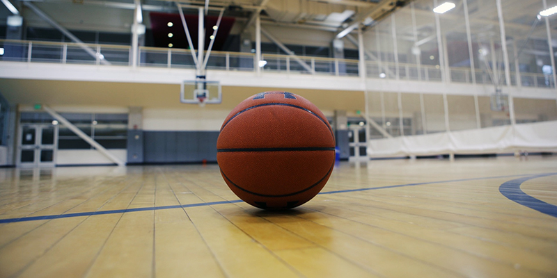 Basketball at rest on the floor of a lined basketball court