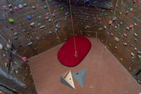 Aerial view of climbing walls on 3 sides and a mat on the ground