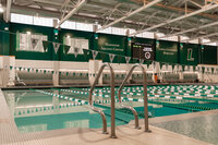 Fresh looking multi-lane swimming pool with green and white flags overhead